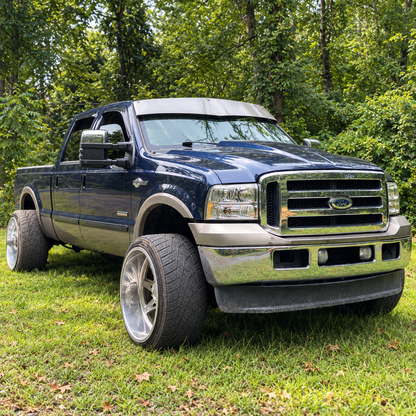 Dark blue Ford Super Duty with a raw-finish TRUBLU Fab 5-inch V drop visor, front three-quarter view