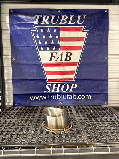 Stainless steel exhaust component on perforated mat with TRUBLU FAB SHOP banner featuring American flag design