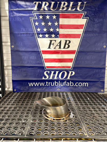 Stainless steel automotive part on perforated tray with TRUBLU FAB SHOP banner background