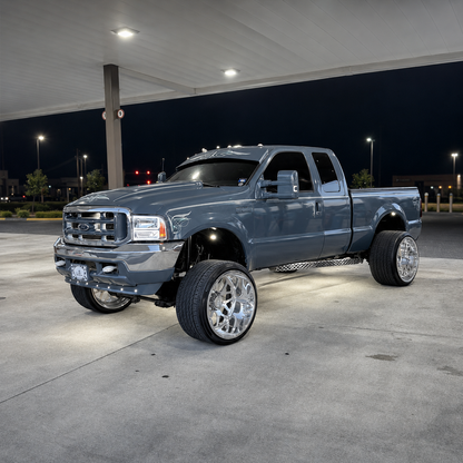 Lifted gray-blue Ford Super Duty with custom pinstriping and TRUBLU Fab straight drop visor at night