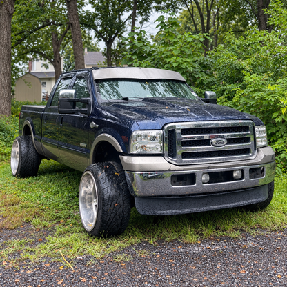 Dark blue Ford Super Duty displaying a raw-finish TRUBLU Fab V drop visor in wet conditions