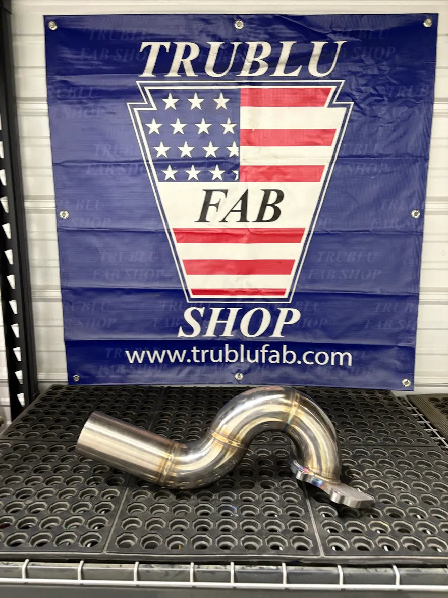 Stainless steel automotive exhaust pipe with welded bends on metal workbench