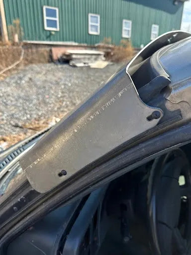 Close-up of a vehicle A-pillar metal reinforcement plate installed by the car door