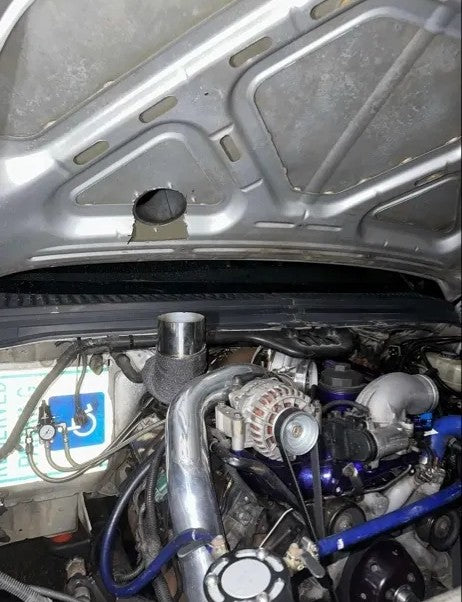 Turbocharged car engine with custom piping and hood vent modification