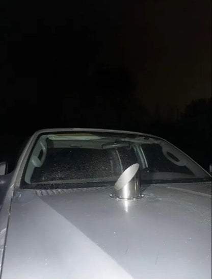 Car hood with metal exhaust stack vent at night, automotive modification visible