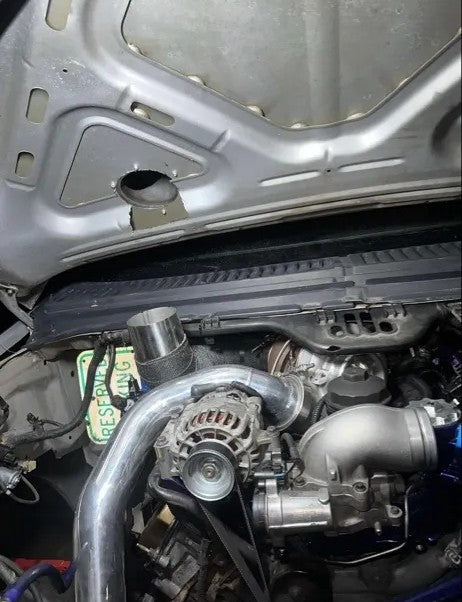 Modified car engine bay with exposed turbocharger and custom piping