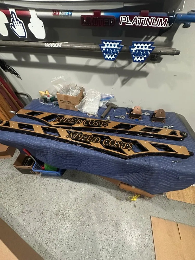 Custom metal side steps with 'SPEED COST$' text, auto parts, workshop setting