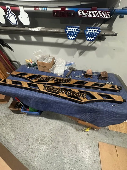 Custom metal side steps with 'SPEED COST$' text, auto parts, workshop setting