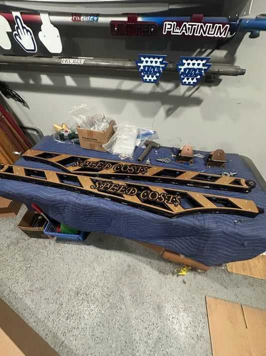 Custom metal side steps with 'SPEED COST$' text, auto parts, workshop setting