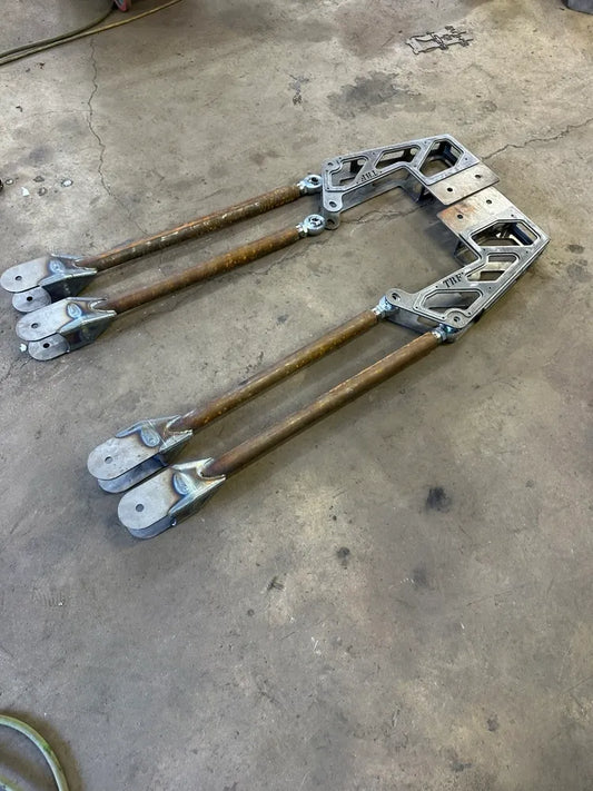 Heavy-duty metal suspension link arms for off-road vehicle on workshop floor