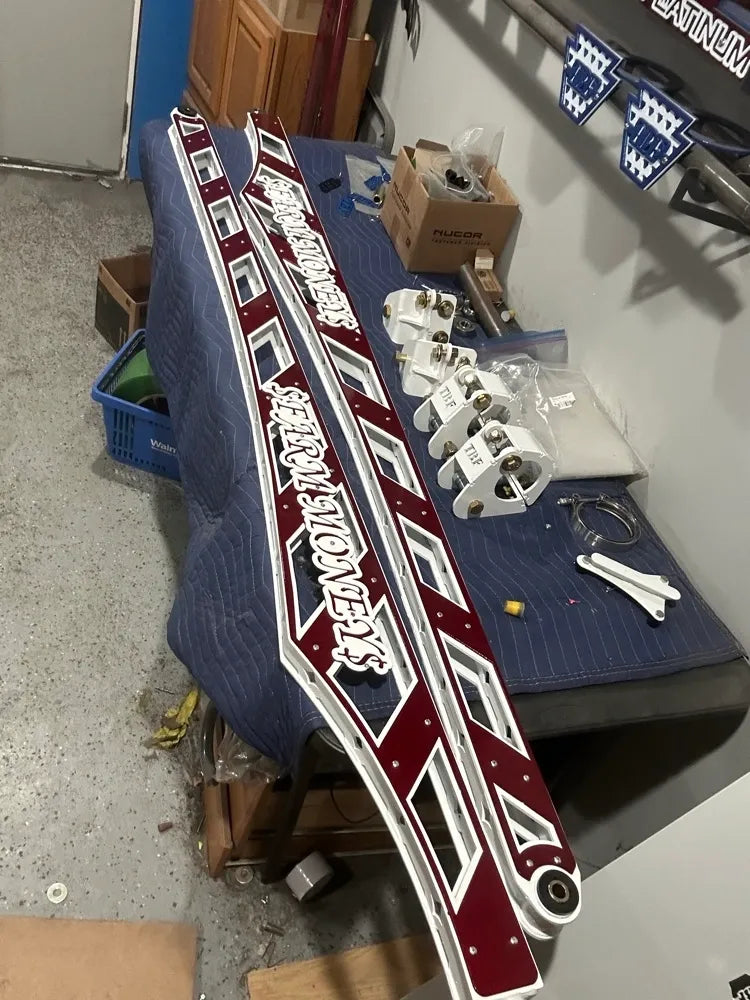 Custom maroon and white metal truck panels with cutout details on shop workbench