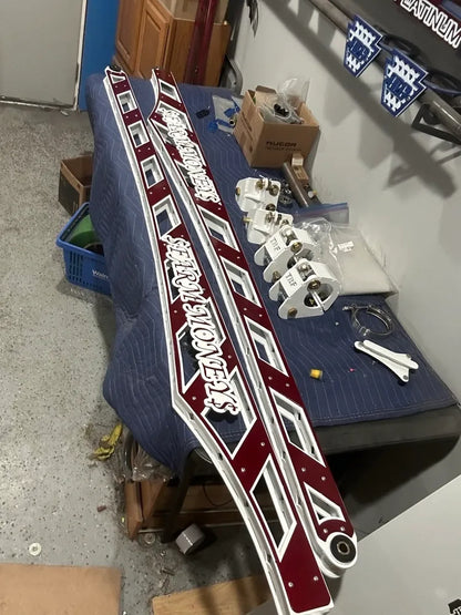 Custom maroon and white metal truck panels with cutout details on shop workbench
