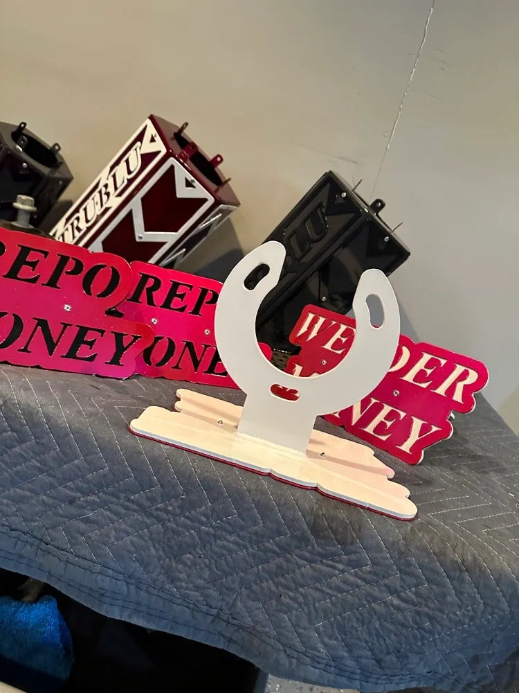 Custom metal sign decor with horseshoe and text, displayed on quilted surface