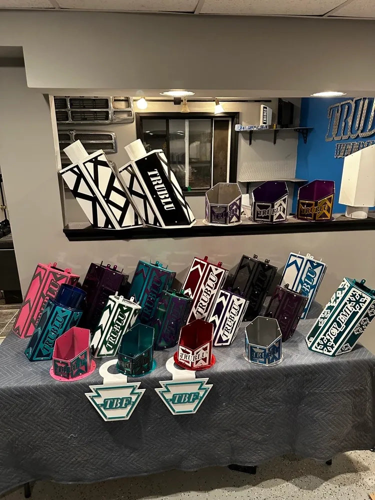 Colorful custom metal fabrications and welded boxes with geometric designs on display table