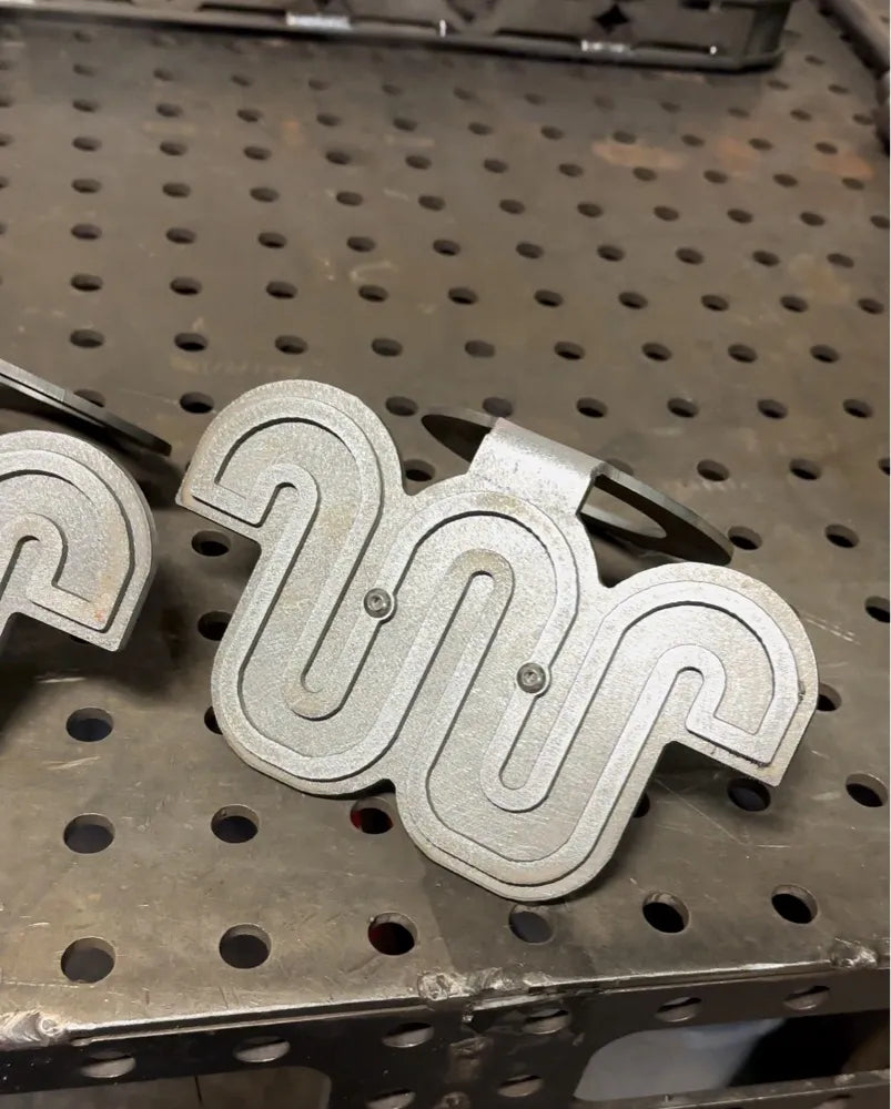 Custom machined metal part with geometric pattern on industrial workbench